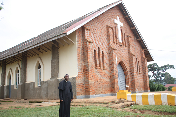 Fr. John Bosco in front of his local church, Our Lady Queen of Apostles in Nkokonjeru