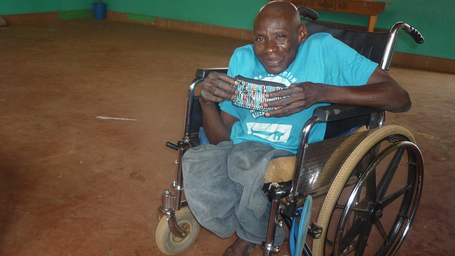 image of a man sitting in a wheelchair holding beaded coin purse