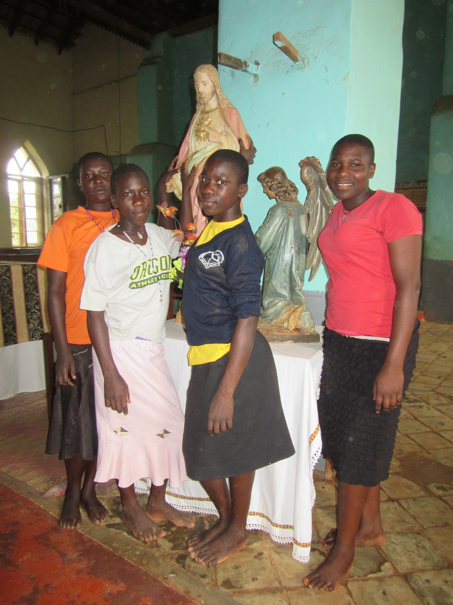 Four teen girls posing by statue of Jesus.