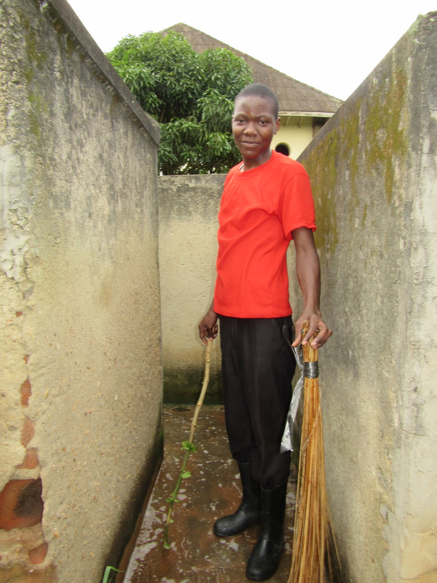 Male teen standing with stick and broom.