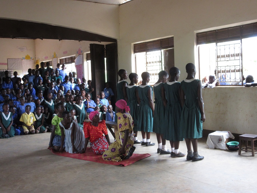 Students from St. Alphonsus Demonstration School, where many CARITAS supporters sponsor a child, present a skit about life in rural Uganda while wearing traditional gomesi.