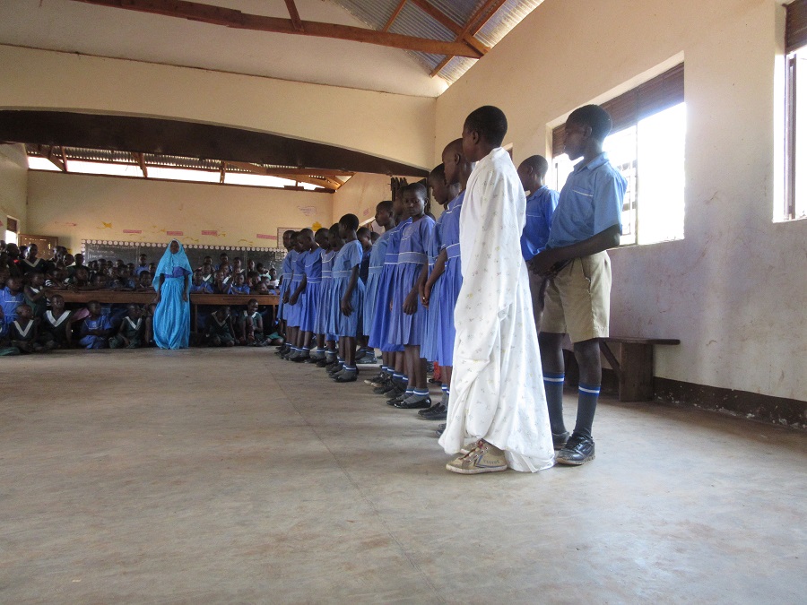 Students from St. Paul Boys School present a song about Mother Mary. Despite the name of the school, the student population is co-ed.