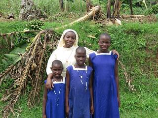 Sister Carolyne stands with Tobit Babirye, Oliver Nakitanda, and Jovia Nabakawa (from left to right), who are sisters, despite having different names. What appear to be surnames, to those unfamiliar with Ugandan naming convention, are individual clan names that are used by their specific clan. Ugandans are readily able to identify them as coming from a specific clan based on their individual clan names. As indicated by her name, Babirye has a twin, David, who was born just after she was.