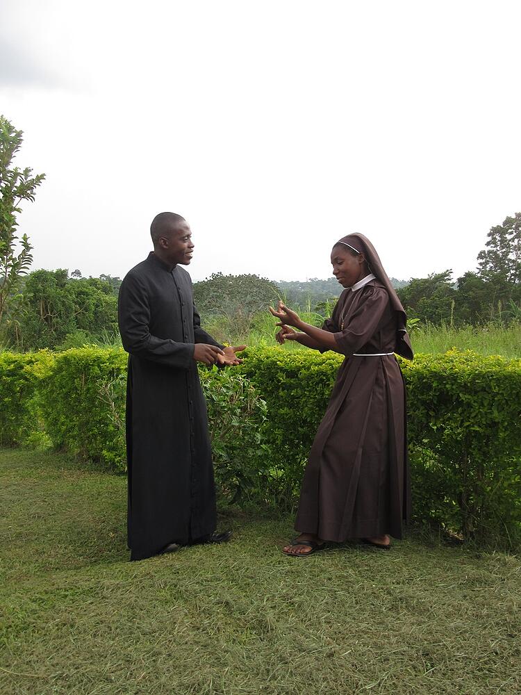 Sr. Carolyne, CARITAS Program Coordinator-Nkokonjeru, and Frank discuss necessary home visits for candidates of our Catholic child sponsorship programs.